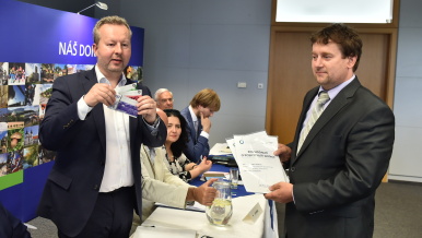 Místopředseda vlády a ministr životního prostředí Richard Brabec předává starostům rozhodnutí o udělení dotace.