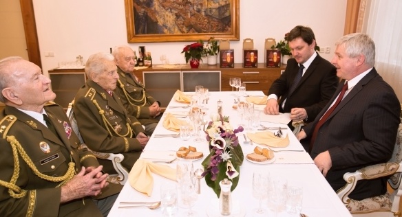 Předseda vlády Jiří Rusnok a vedoucí Úřadu vlády Radek Augustin s válečnými hrdiny ve Strakově akademii, 13. prosince 2013.