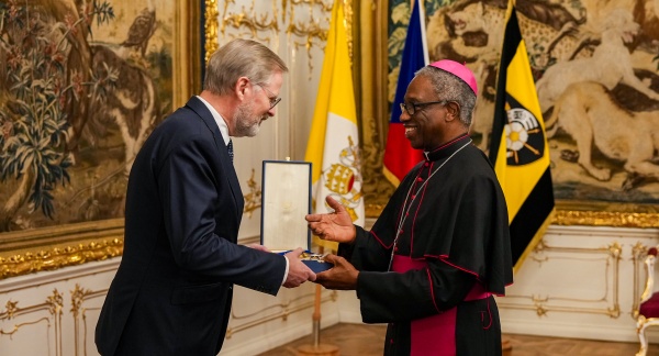 Premiér Petr Fiala přebírá z rukou apoštolského nuncia v ČR, arcibiskupa Jude Thaddeuse Okola Velký kříž Řádu Pia IX., 20. listopadu 2025.