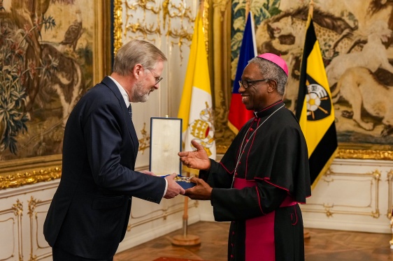 Premiér Petr Fiala přebírá z rukou apoštolského nuncia v ČR, arcibiskupa Jude Thaddeuse Okola Velký kříž Řádu Pia IX., 20. listopadu 2025.